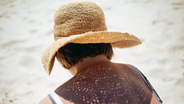 Backview-of-a-Woman-Sitting-on-Beach