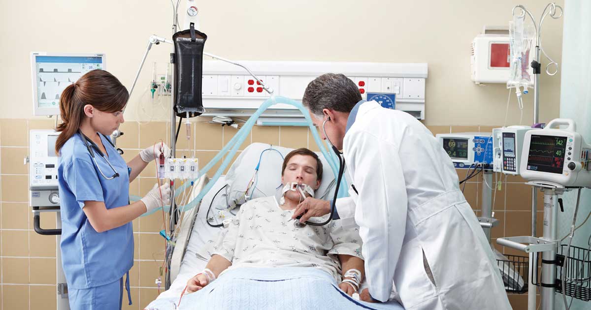 A patient and clinicians in an intensive care unit. 